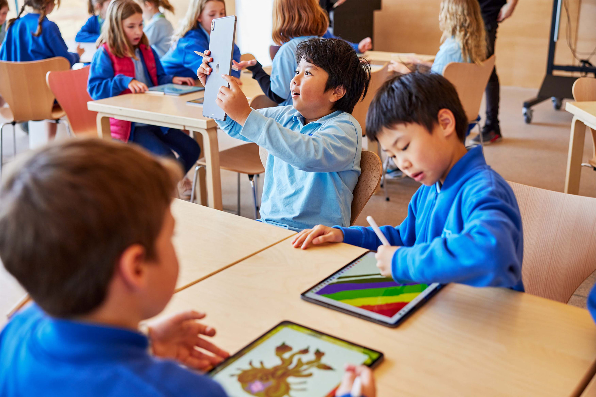 Young students at table using iPad Pro and Apple Pencil. The power and portability of iPad Pro, combined with the precision of Apple Pencil, enables participants to foster their creativity.